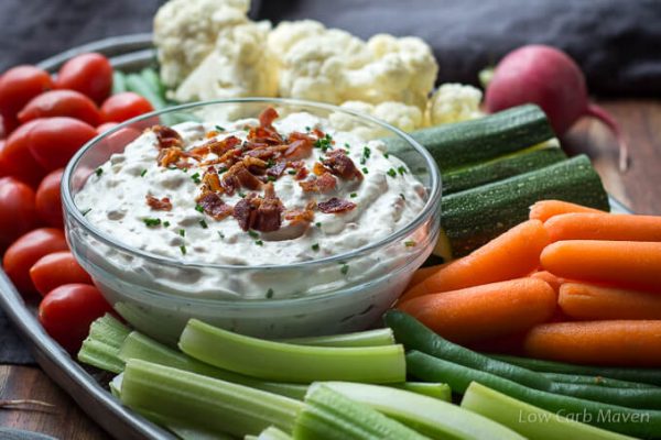 Creamy Bacon Horseradish Dip with crumbled bacon on a veggie tray with low varb vegetables: grape tomatoes, celery, blanched green beans, carrots, zucchini spears and raw cauliflower.