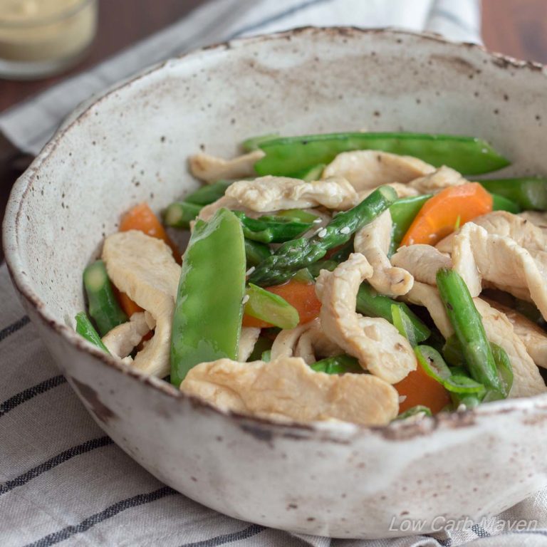 Chicken asparagus stir fry with carrots and snow peas in a bowl.