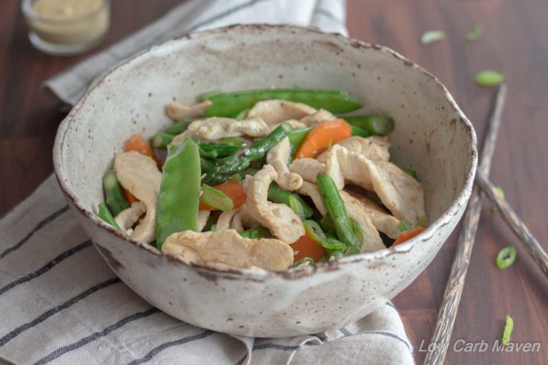 Chicken asparagus stir fry with carrots and snow peas in a bowl.