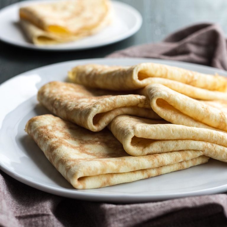 Folded low carb coconut flour crepes on a plate with napkin.