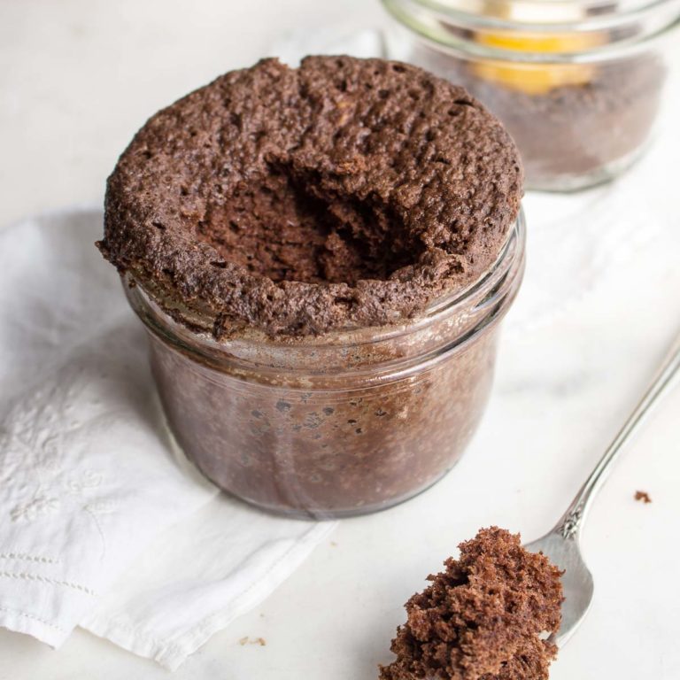 chocolate peanut butter mug cake in a mason jar with a bite missing