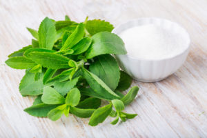 Stevia plant and powdered stevia in a bowl