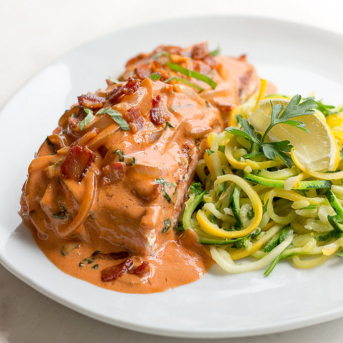 Cooked salmon filet sauced with creamy Tuscan sauce of tomato, bacon, basil, cream and vodka with spirilzed zucchini on the side.
