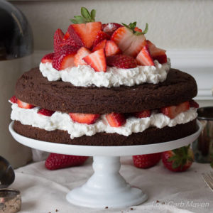 Low carb chocolate cake made with almond flour and filled with strawberries and whipped cream or whipped coconut cream. dairy free, keto, thm