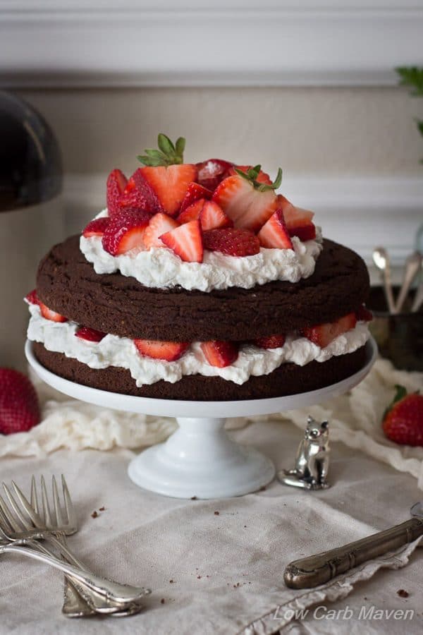 Low carb chocolate cake made with almond flour and filled with strawberries and whipped cream or whipped coconut cream. dairy free, keto, thm