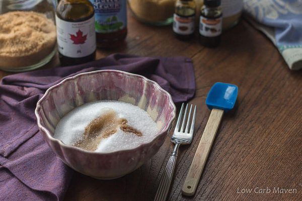 Sugar-free sugar substitute in a bowl with maple extract, ready to stir with a fork.