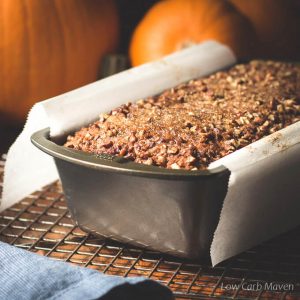 Pumpkin bread made with coconut flour in a pan with pumpkins and blue napkin.