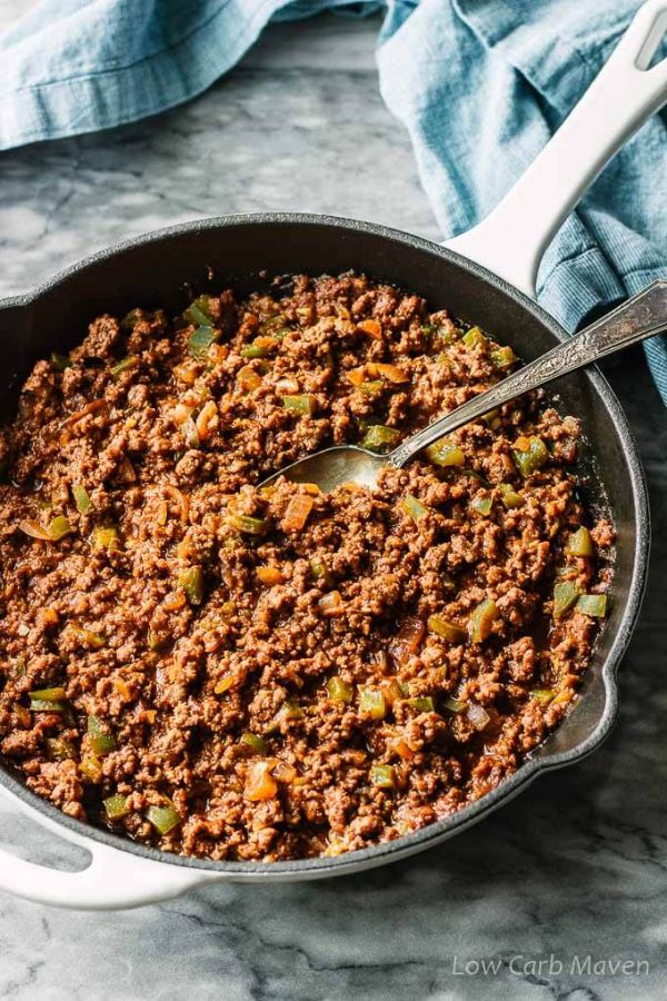 Homemade sloppy joes meat with green bell peppers and onions in a pan with serving spoon.