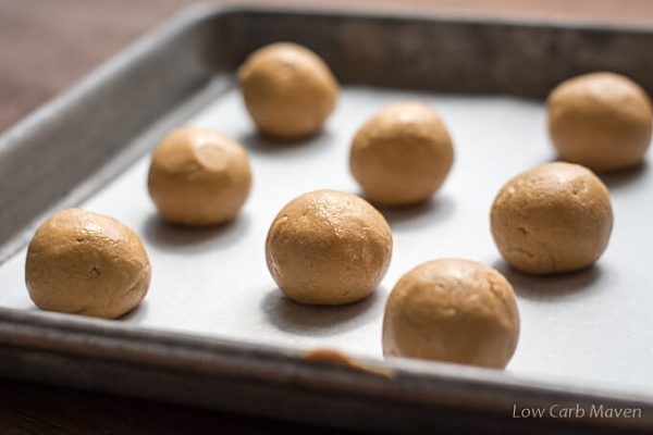 Peanut butter balls on a parchment lined cookie sheet.