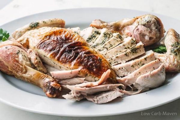 Sliced oven roasted chicken with herbs and herb butter.