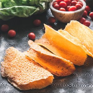 cheddar cheese taco shells on a tray with tomatoes and lettuce