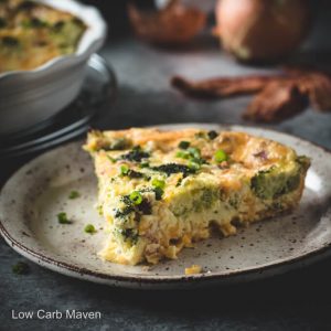 Slice of broccoli cheddar quiche with bacon on a plate.