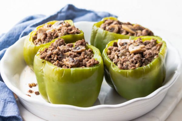 Green bell peppers stuffed with ground beef, mushrooms and onions for Philly cheesesteak stuffed peppers. 