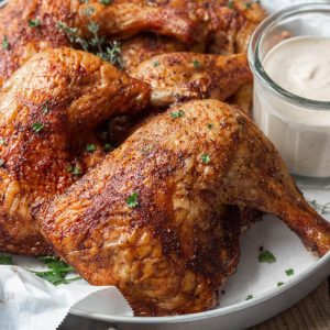 Smoked chicken leg quarters with dry rub and Alabama white sauce.