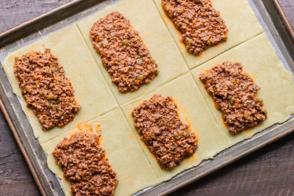 Homemade hot pockets with sloppy Joe filling before folding over and baking.