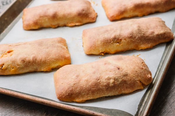 Homemade baked sloppy joe hot pockets on a sheet pan.