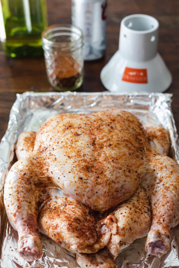 Dry rubbed beer can chicken in a pan before cooking.