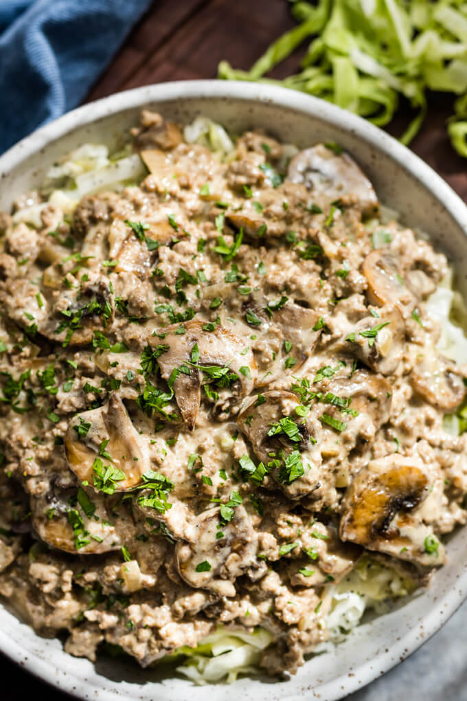 Ground beef stroganoff with mushrooms over cabbage noodles topped with parsley.