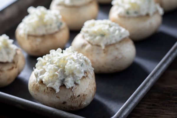 Crab stuffed mushrooms on a sheet pan before baking.