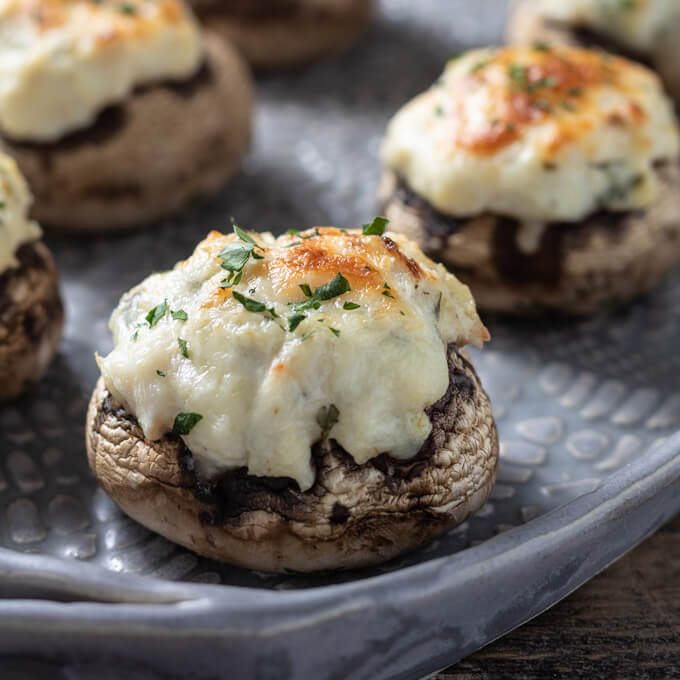 Creamy crab stuffed mushrooms on a platter.