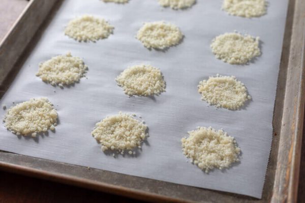 Parmesan crisps on parchment lined baking sheet before baking.