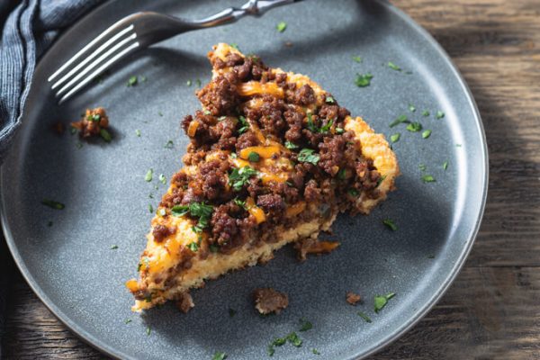 A slice of sloppy Joe Casserole on plate with fork.