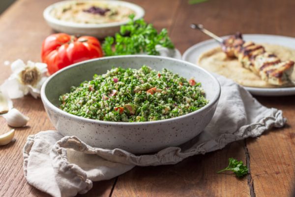Cauliflower tabbouleh with parsley and tomatoes served with grilled chicken kebab.