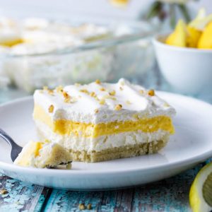 Lemon lush layered dessert on a plate with fork.
