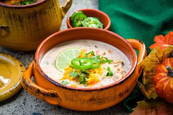 A bowl of low carb chicken taco soup with cheese, cilantro, and jalapeno garnish
