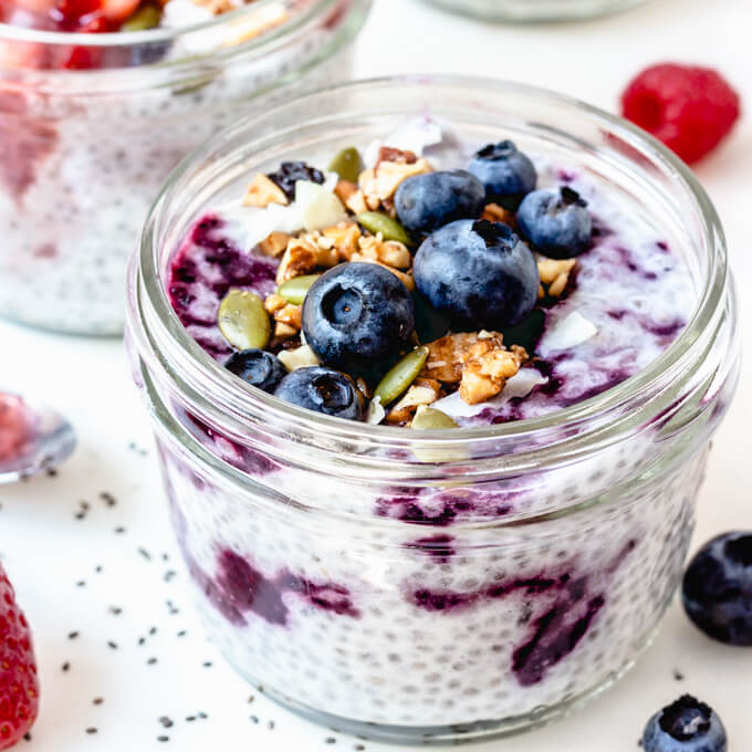 Keto chia seed pudding swirled with jam and topped with blueberries, granola and pumpkin seeds