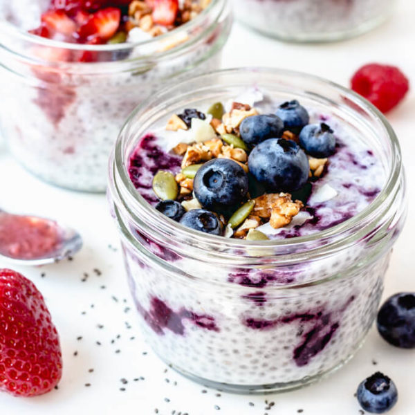 Keto chia seed pudding swirled with jam and topped with blueberries, granola and pumpkin seeds