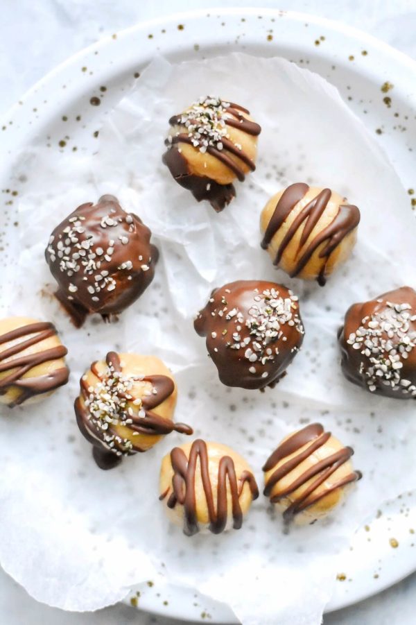 Vegan keto peanut butter truffles drizzled with chocolate on a plate