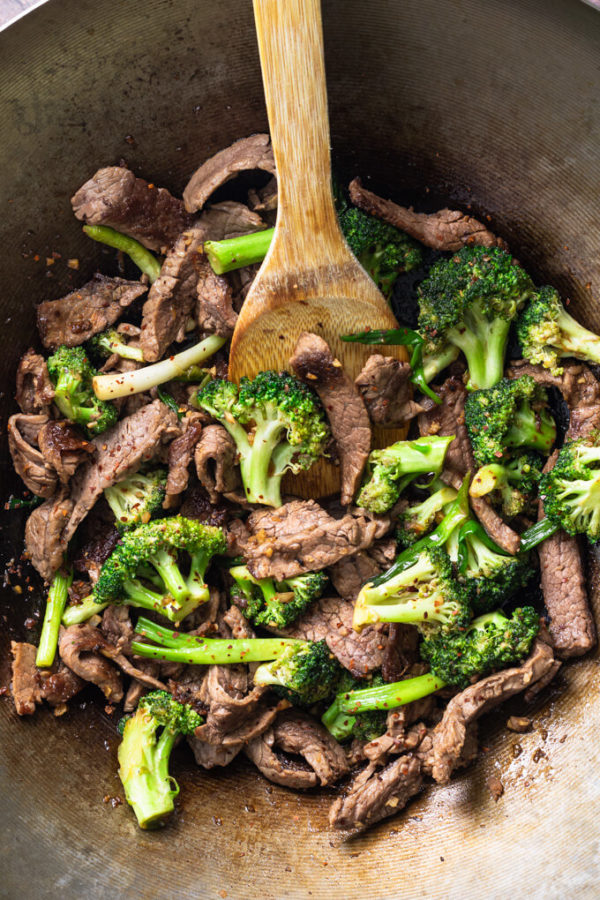 Keto beef and broccoli stir fry in a wok with bamboo spoon