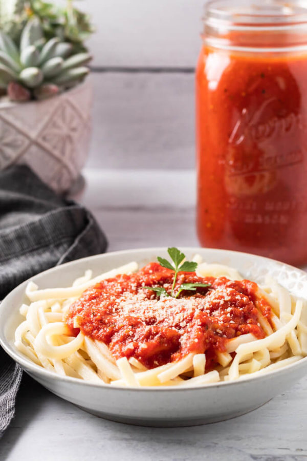 Keto Tomato sauce on low carb pasta in a bowl with black napkin and jar of sauce behind.