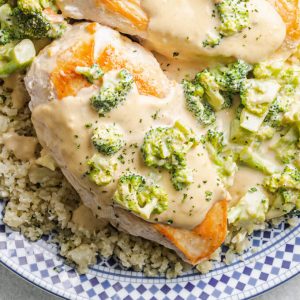 Chicken Broccoli Alfredo over cauliflower rice on a blue and white patterned plate