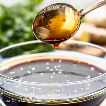 Keto teriyaki sauce dripping from spoon into sauce filled bowl with ingredients behind.