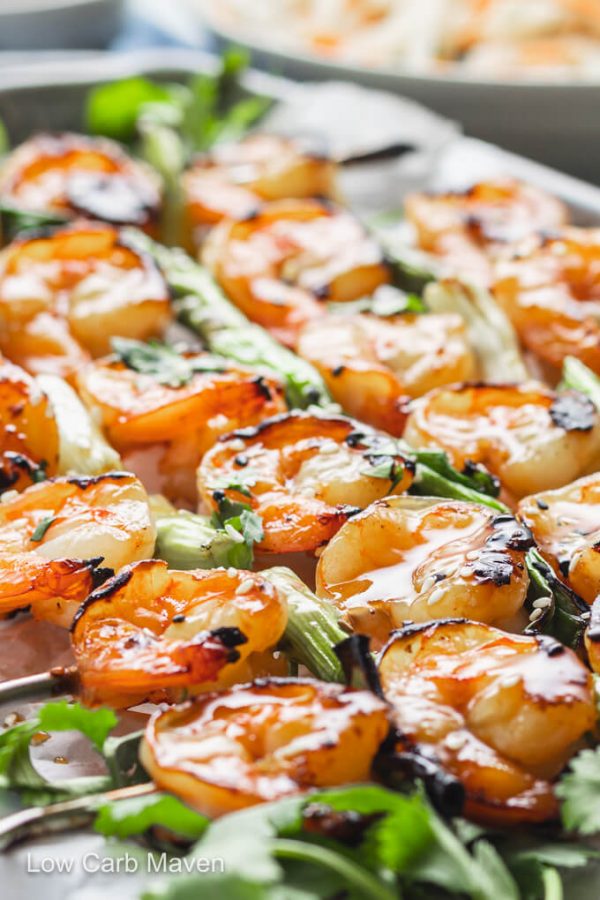 Teriyaki shrimp skewers with scallions and cilantro on platter