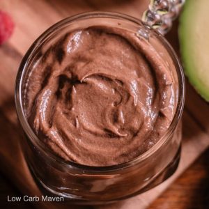 Top down view of keto chocolate avocado pudding with swirled top in glass cup.